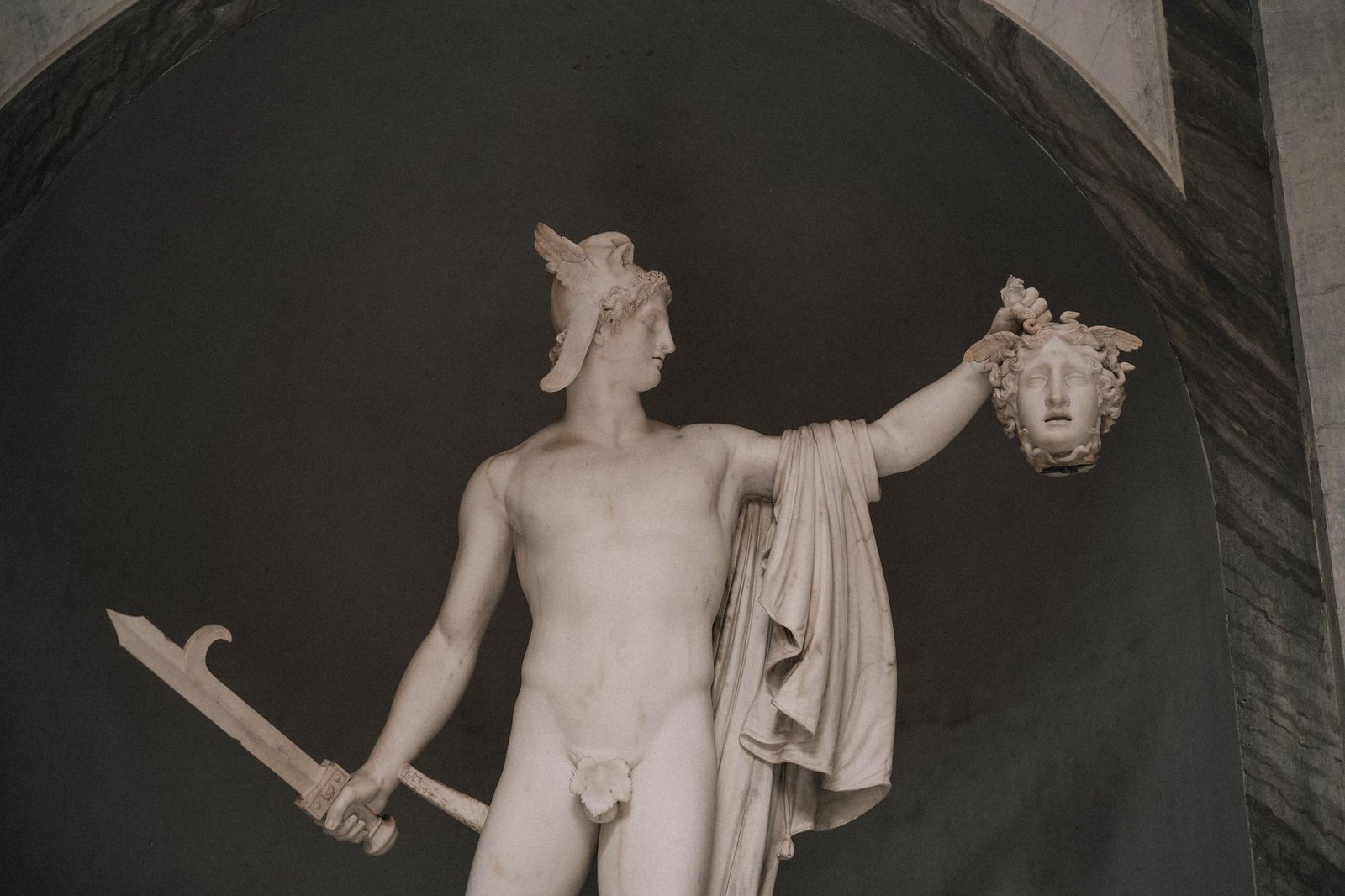 Marble statue of Perseus holding Medusa’s head and a sword, illustrating Greek mythology aegis-related symbolism