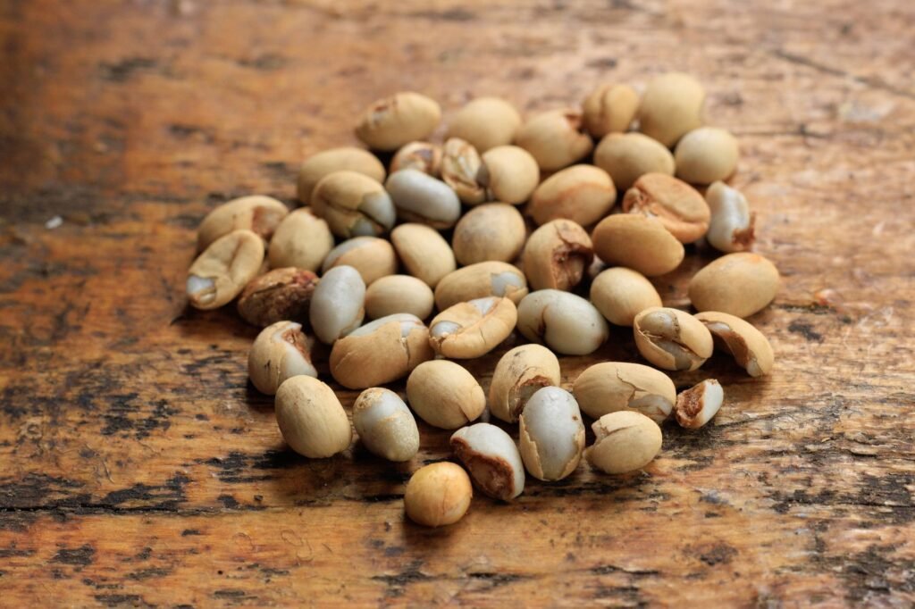 Close-up of raw soybeans scattered on a wooden surface