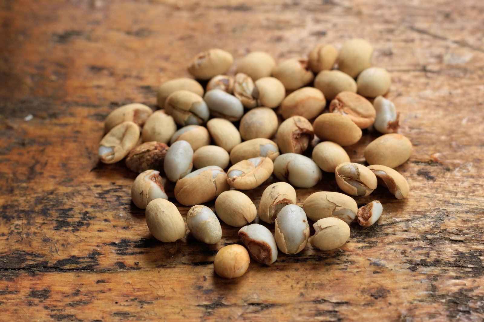 Close-up of raw soybeans scattered on a wooden surface