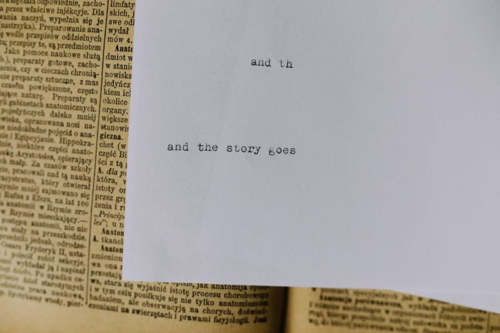 Close-up of typed words and the story goes on white paper resting over an open book