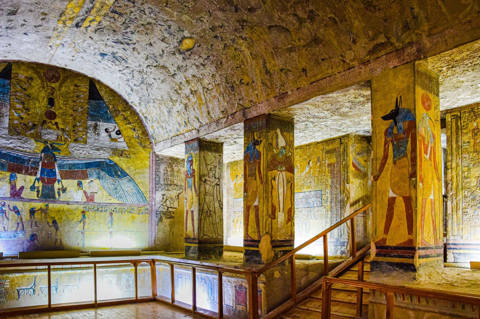 Interior of an ancient Egyptian tomb with colorful wall paintings, hieroglyphs, and the Eye of Horus symbol