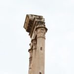Ancient Roman column ruins beneath a clear sky, evoking the Roman fasces symbol’s historical setting