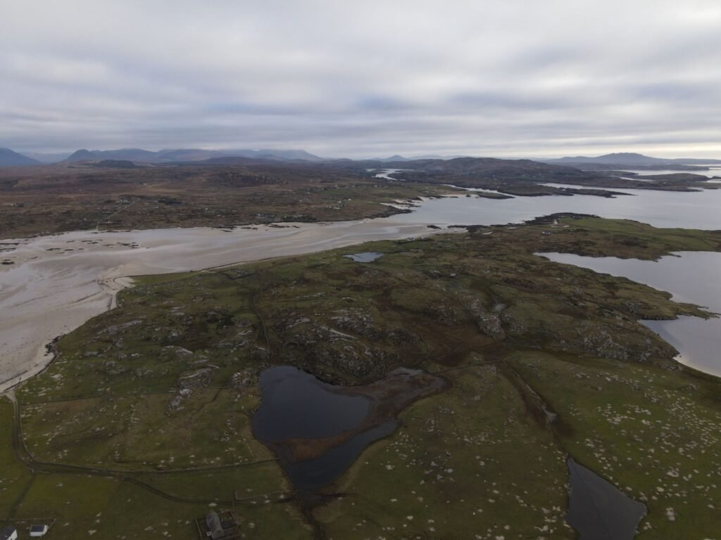 Aerial view of rugged coastal rocks and water under a cloudy sky, evoking Fionn Mac Cumhaill and the Salmon of Knowledge