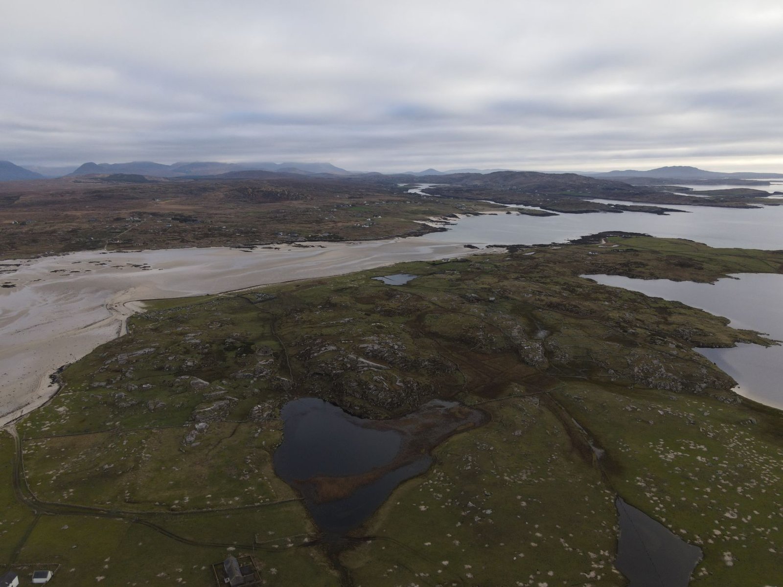 Aerial view of rugged coastal rocks and water under a cloudy sky, evoking Fionn Mac Cumhaill and the Salmon of Knowledge