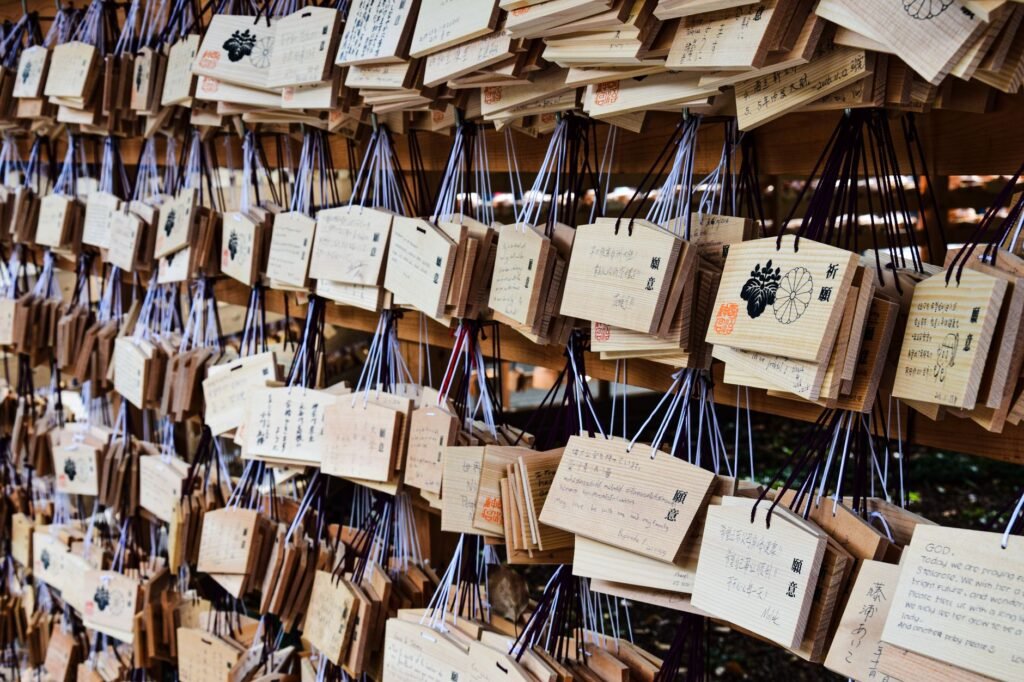 Wooden prayer plaques with handwritten wishes hanging at a Japanese Shinto shrine