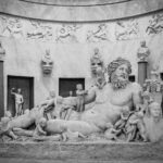 Reclining ancient Greek statue in a museum, evoking the Greek creation myth and origins of the gods