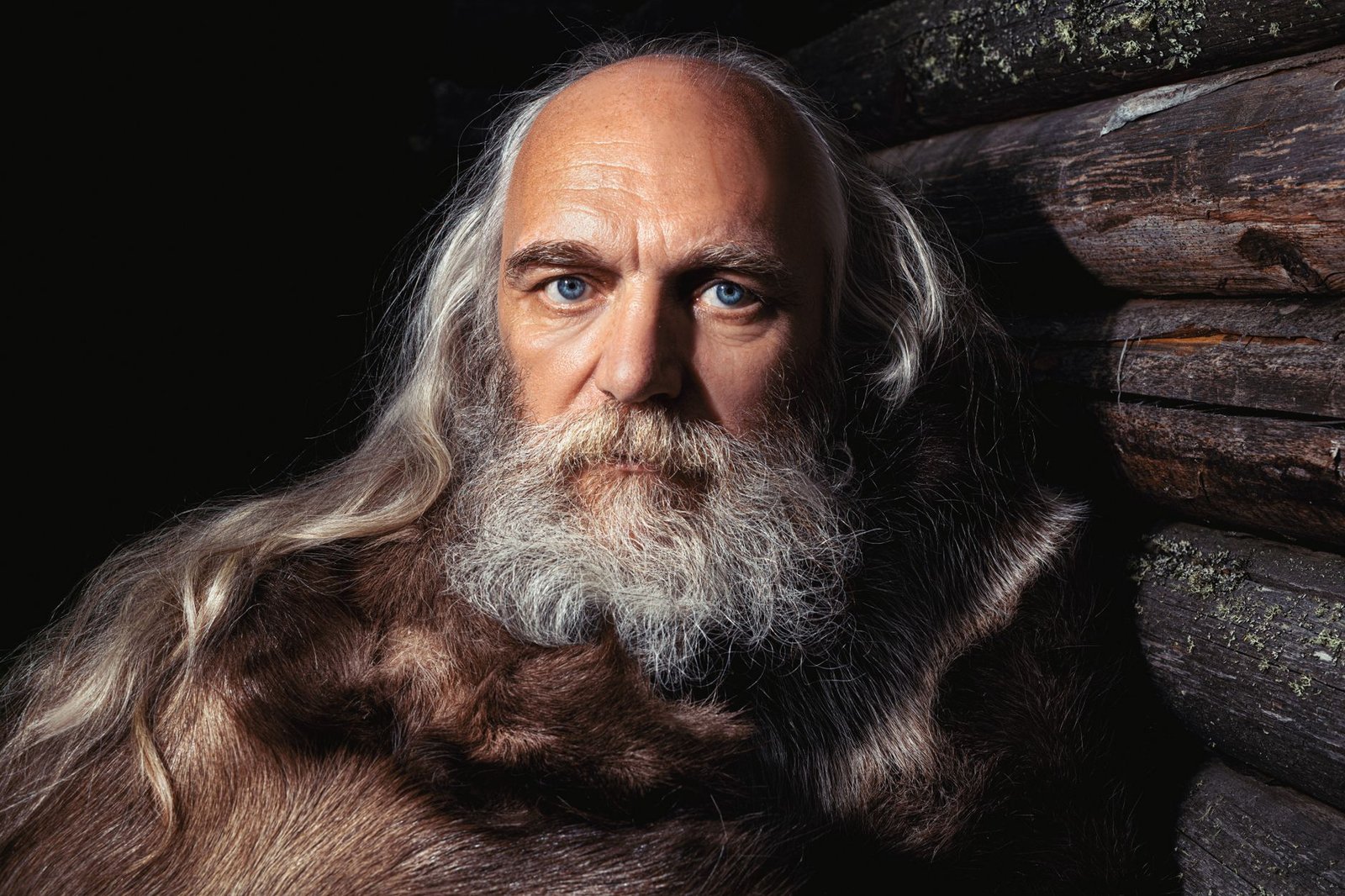 Elderly Odin with long gray hair and beard in a fur cloak, evoking the myth of how Odin lost his eye