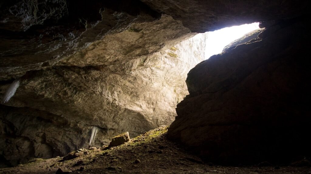 a cave with a light coming through it
