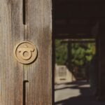 Close-up of a rustic wooden door with a round brass handle, no Celtic symbol visible