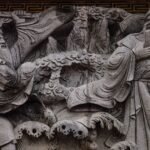Intricate stone carving of traditional Chinese figures in historical attire, showing Izanagi mythology-inspired imagery