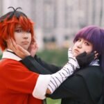 Two anime cosplayers posing outdoors with playful expressions, dressed as characters from Izanagi and Yomi mythology.