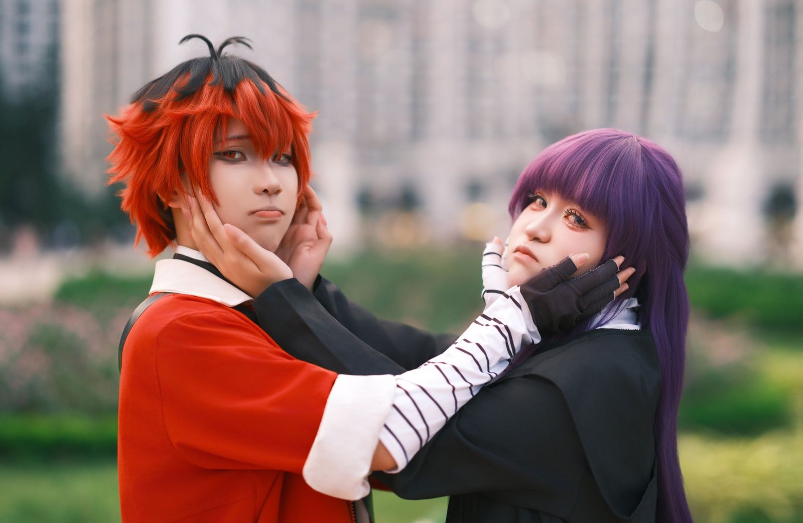 Two anime cosplayers posing outdoors with playful expressions, dressed as characters from Izanagi and Yomi mythology.