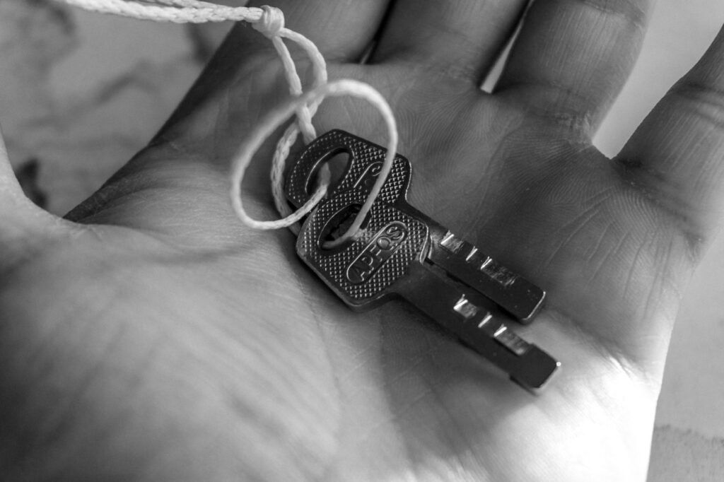 Close-up of a hand holding a key attached to a string, representing the Key of Janus.