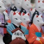 Traditional Japanese fox figurines in colorful kimonos representing kitsune from Japanese fox folklore