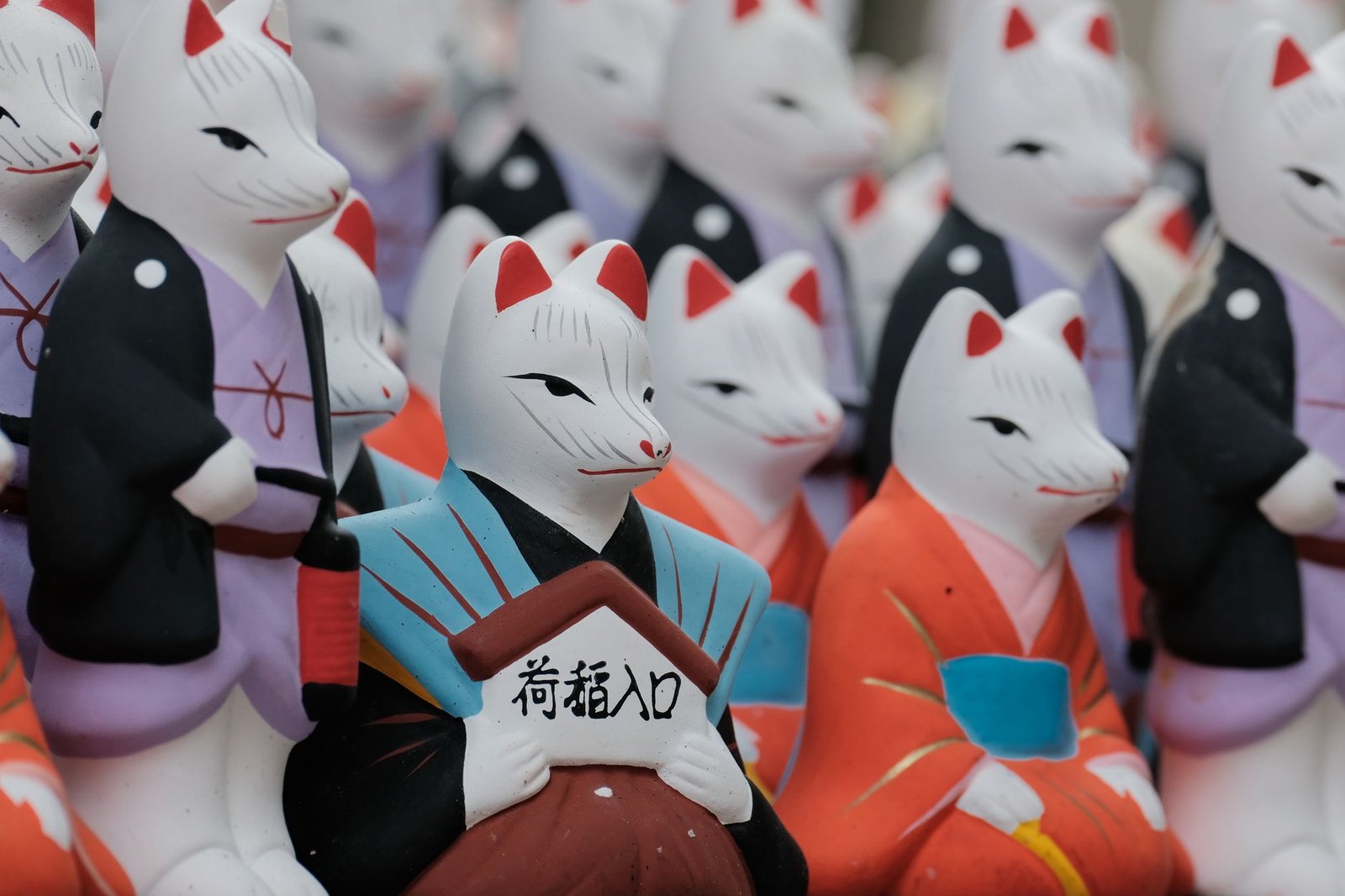 Traditional Japanese fox figurines in colorful kimonos representing kitsune from Japanese fox folklore