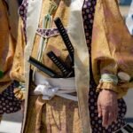 Japanese samurai in traditional attire wearing swords at a cultural festival, including Kusanagi no Tsurugi symbolism