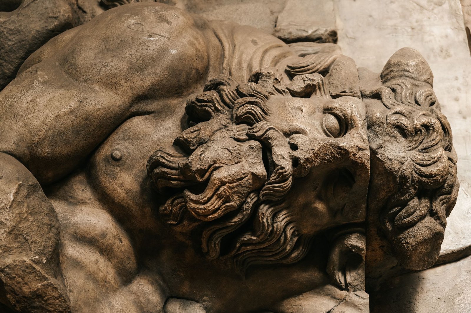 Close-up of an ancient stone sculpture of Mucius Scaevola, a muscular bearded Roman man with a stern expression