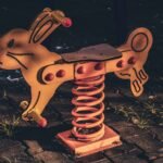 Vintage rabbit-shaped spring rider playground toy on cobblestone ground, evoking the White Hare of Inaba myth