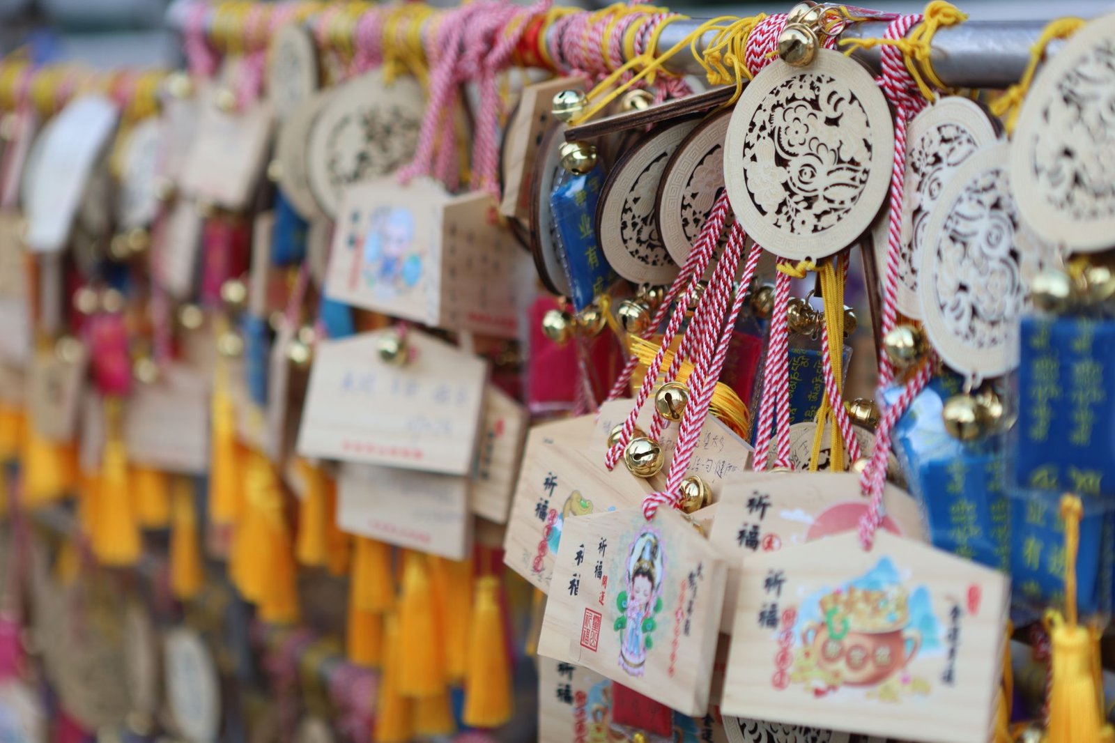 Colorful omamori charms and ema wooden prayer plaques hanging at a Japanese shrine