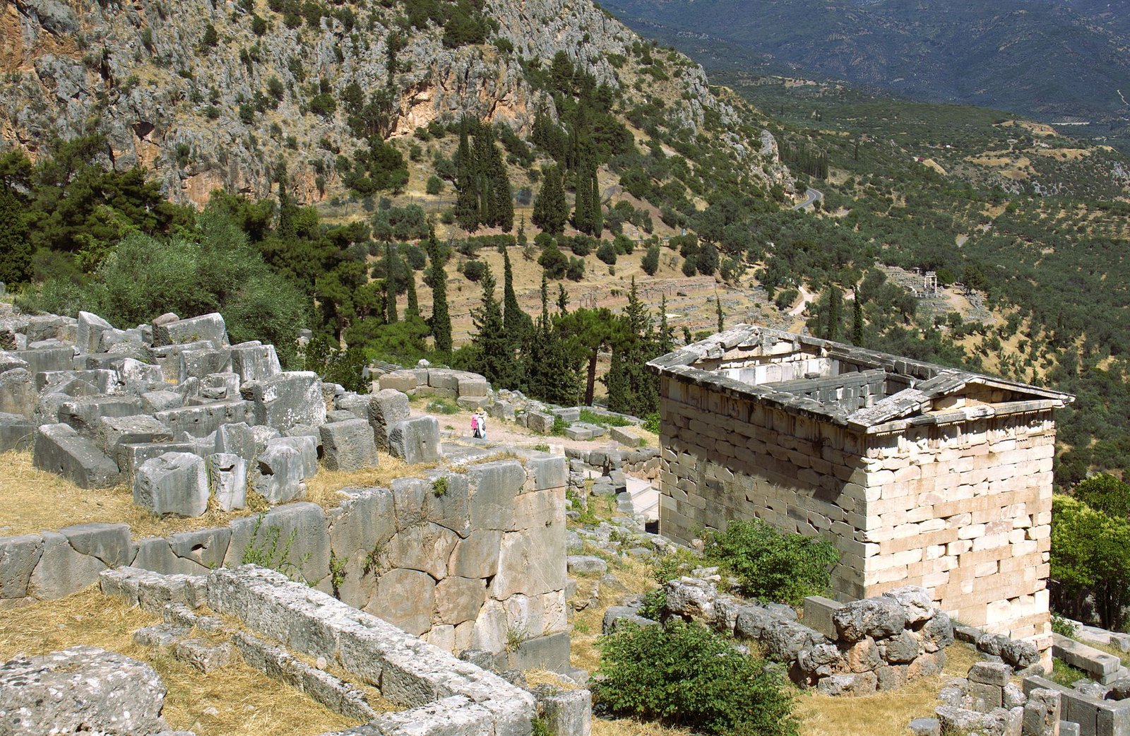Ancient stone ruins with the Delphi omphalos in a mountainous landscape background