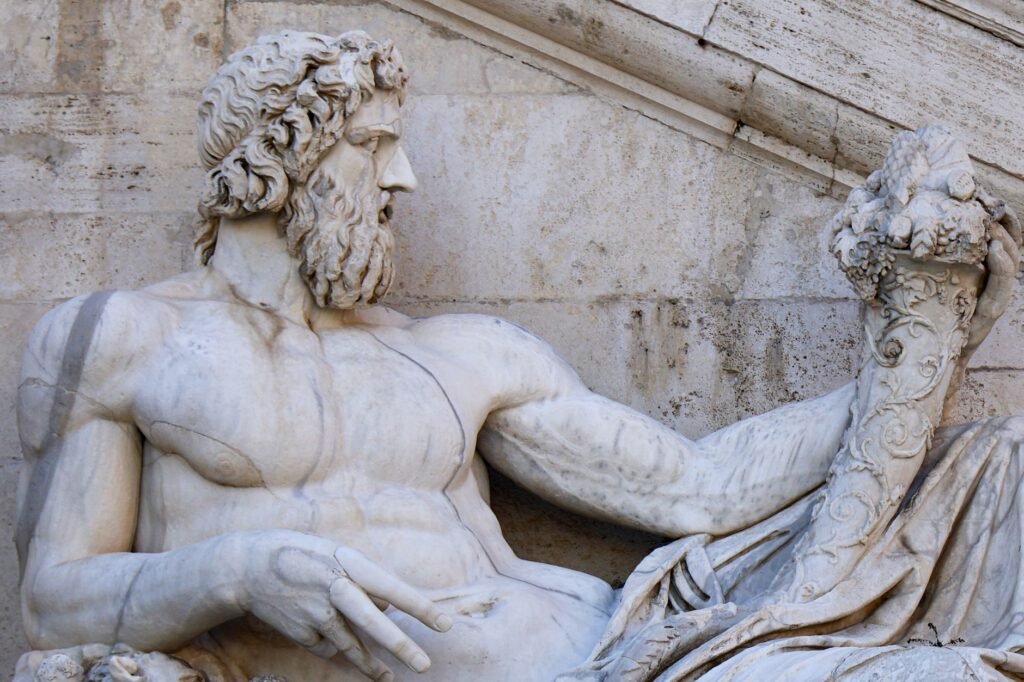 Classical marble statue of Pluto, bearded and holding a cornucopia, in close-up view