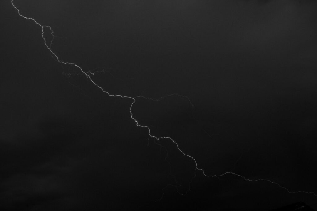 Bright lightning bolt cutting through a dark stormy sky, evoking Raijin, the Japanese god of thunder