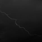 Bright lightning bolt cutting through a dark stormy sky, evoking Raijin, the Japanese god of thunder