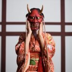 Person in a traditional Japanese kimono wearing a red oni demon mask, inspired by Japanese mythology creation myth