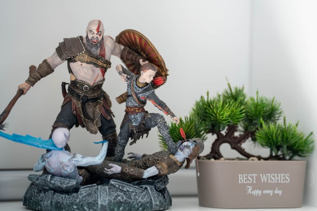 Fantasy warrior action figures beside a small potted bonsai tree with a Best Wishes message, suggesting the House of Atreus m