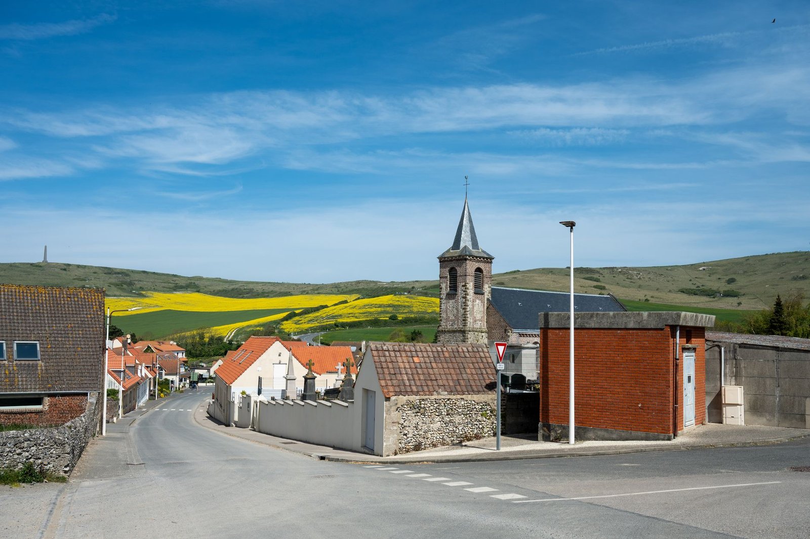 Small Irish village with a church tower and countryside under a blue sky, evoking Tochmarc Étaíne