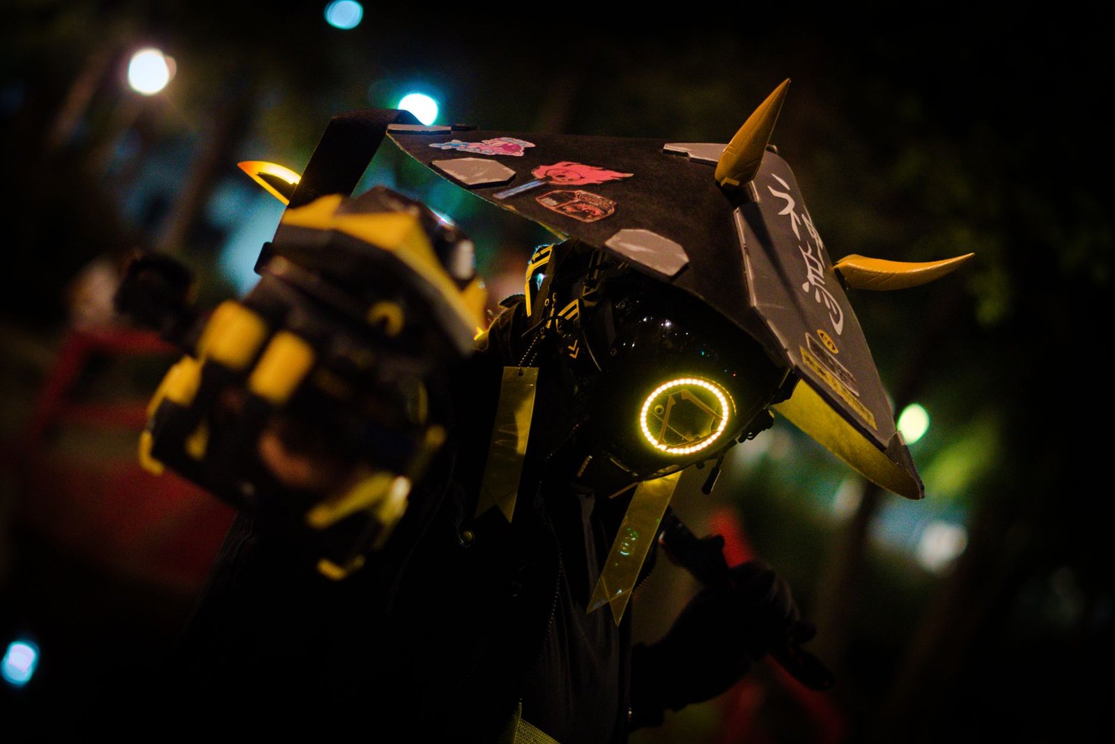 Close-up of a person in a glowing futuristic robotic bull costume at night, evoking Tsukuyomi imagery