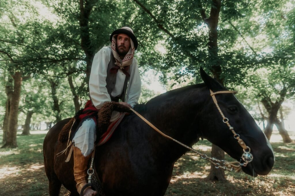 Man in traditional Middle Eastern attire rides a black horse through a forest, evoking Tarbh Uisge folklore