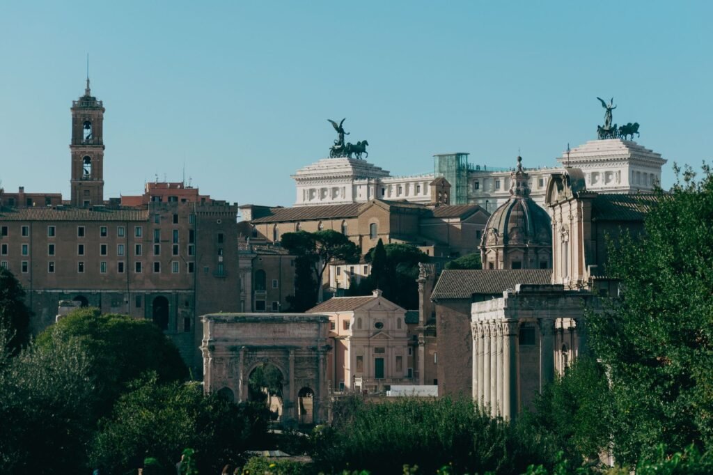 Panoramic view of ancient Roman architecture and monuments beneath a clear blue sky