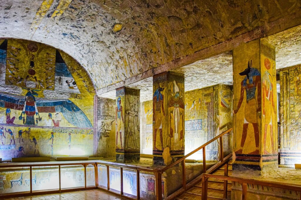 Colorful ancient Egyptian tomb wall paintings and hieroglyphs depicting Anubis, the jackal-headed god of the dead