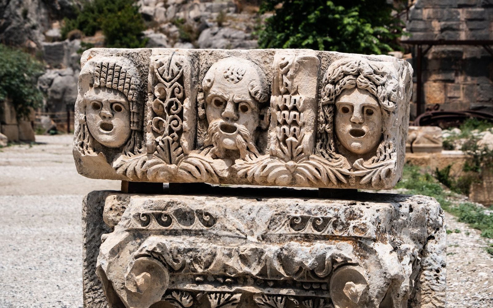 Ancient triple-faced stone sculpture representing Hecate in Greek mythology at an archaeological site