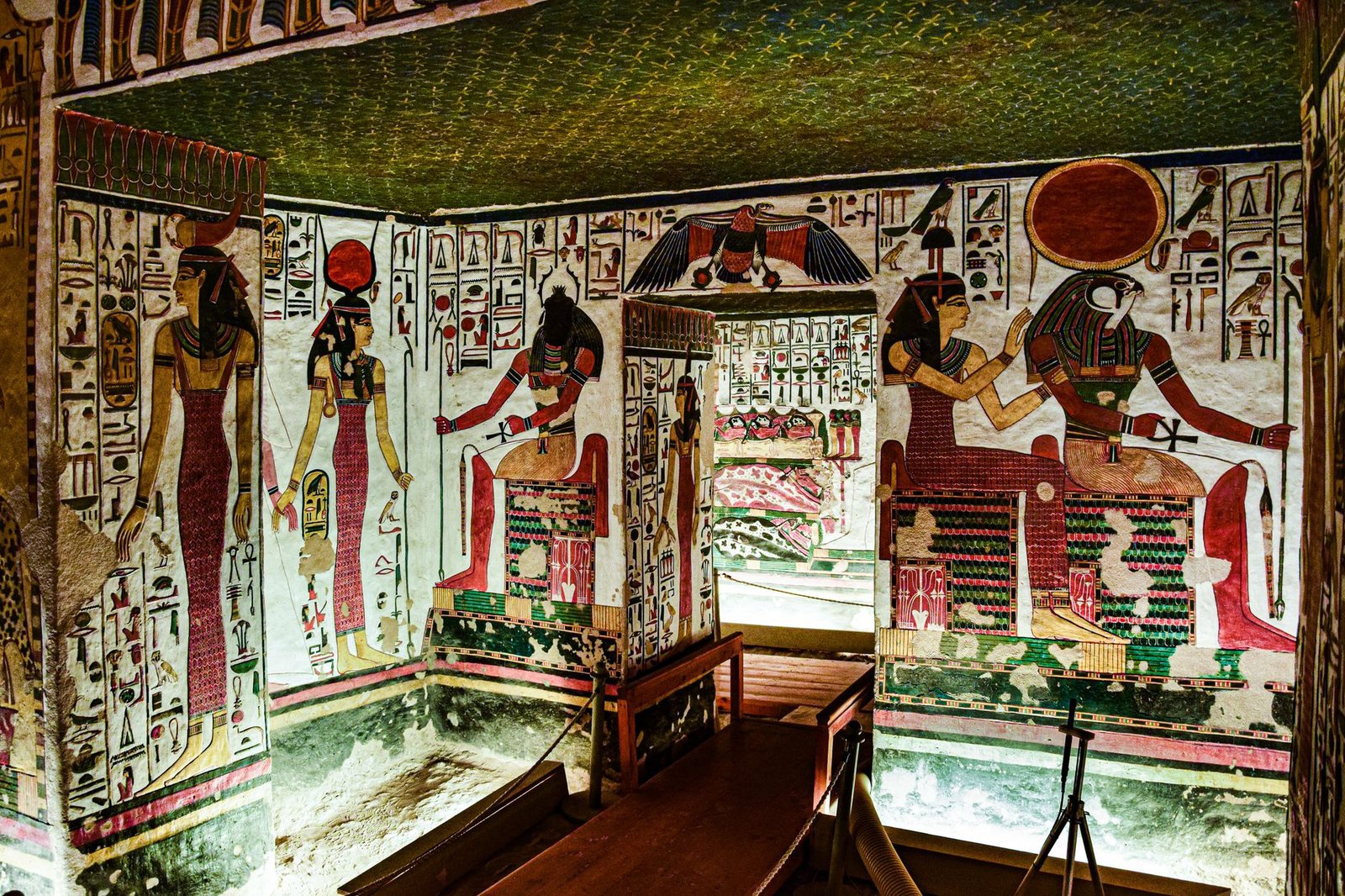 Ancient Egyptian tomb interior with colorful hieroglyphics and wall paintings of Nephthys in Egyptian mythology