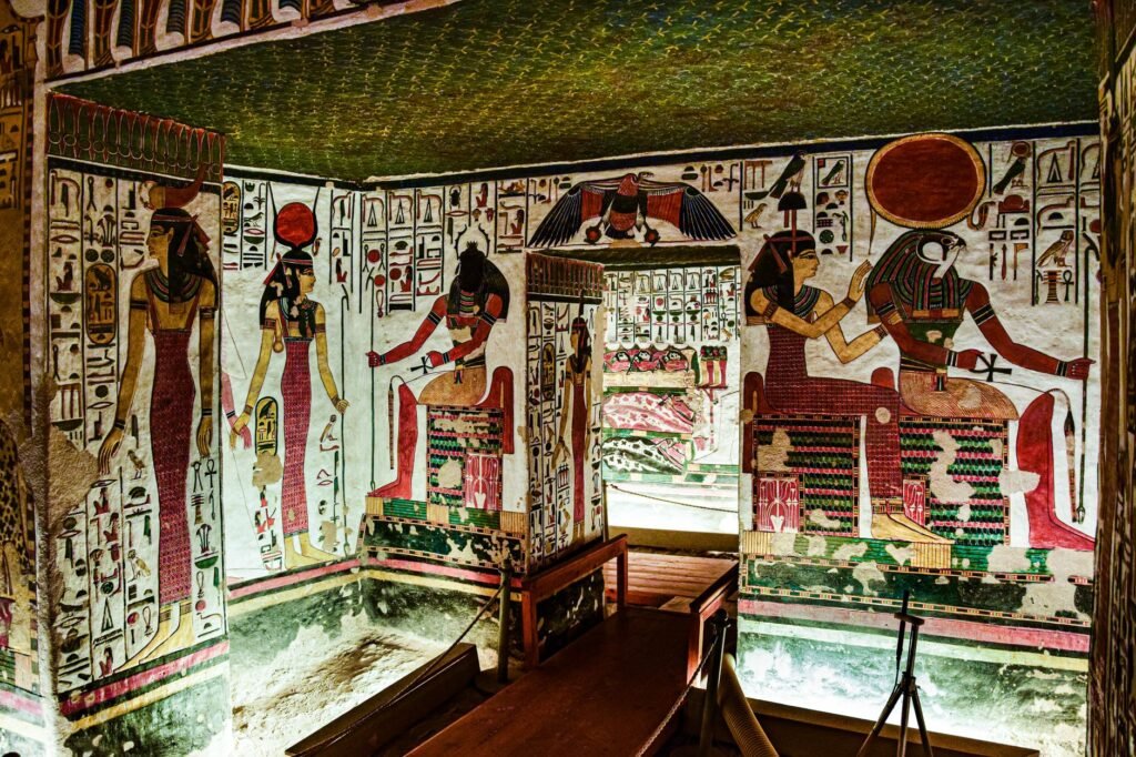Ancient Egyptian tomb interior with colorful hieroglyphs and painted deity figures, including Nephthys in Egyptian mythology