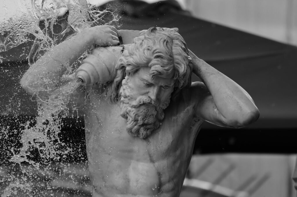 Classical statue of Triton in Greek mythology, a bearded sea god with water splashing around him