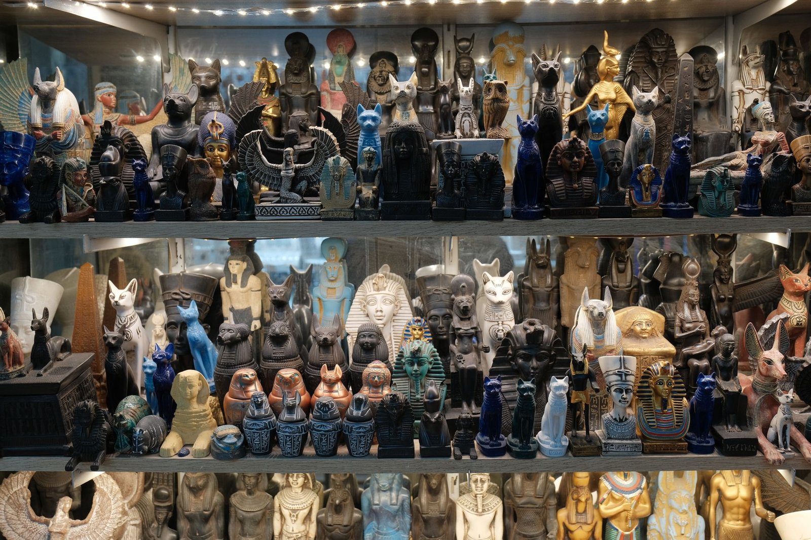 Ancient Egyptian statues and artifacts in a museum display, including a jackal figure representing Wepwawet