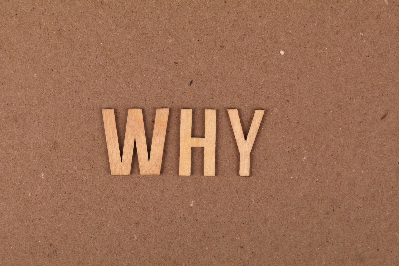 Wooden letters spelling WHY on a brown background for why was Idun kidnapped in Norse mythology